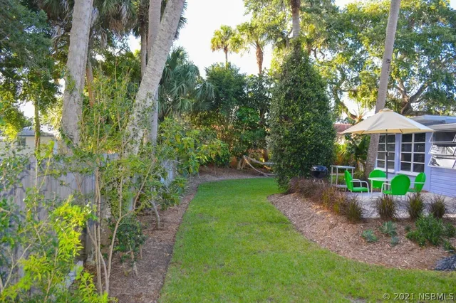 a view of a front of house with a yard and potted plants