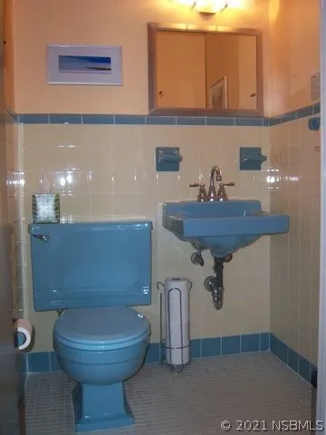 a bathroom with a toilet a sink and mirror