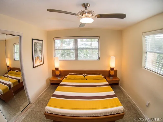 a spacious bedroom with a bed and wooden floor
