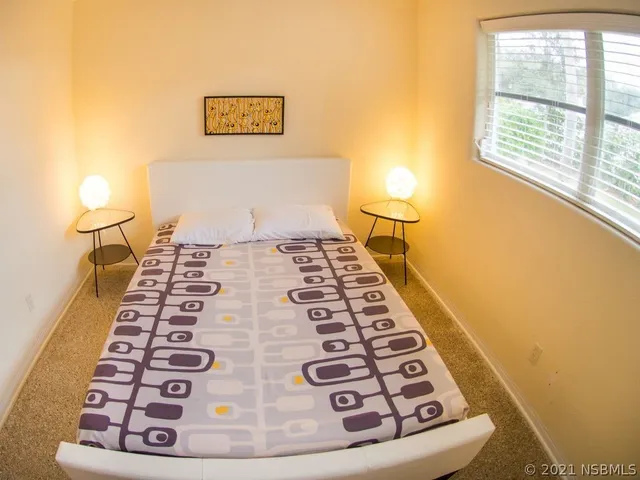 a bedroom with a bed and a window