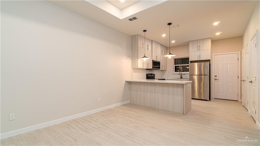 11500 North 25th Lane, Unit 2 McAllen, TX 78504 - Photo 5 of 19 a kitchen with white cabinets and refrigerator