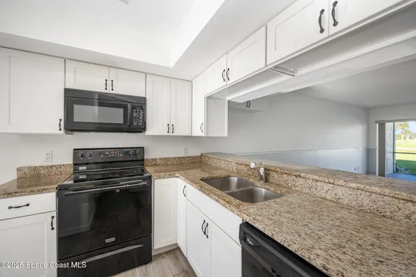 a kitchen with granite countertop a stove and a sink