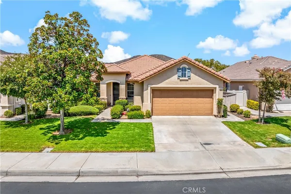a front view of a house with a yard and potted plants