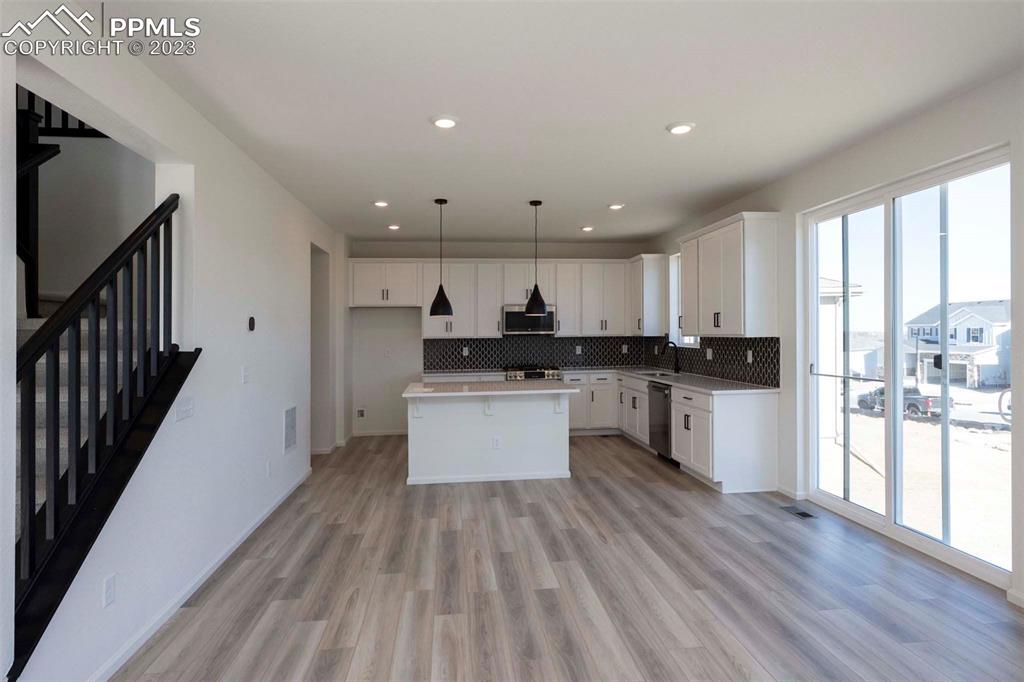 2039 Peachleaf Loop Castle Rock, CO 80108 - Photo 9 of 23 a kitchen with a refrigerator and white cabinets