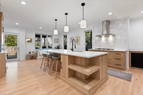a kitchen with stainless steel appliances granite countertop a sink a stove and a refrigerator