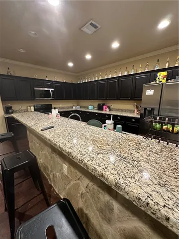 a kitchen with stainless steel appliances granite countertop a sink and a stove top oven