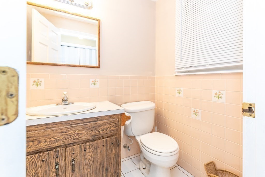 8 Comanche Circle Billerica, MA 01821 - Photo 14 of 35 a bathroom with a granite countertop toilet a sink and a mirror
