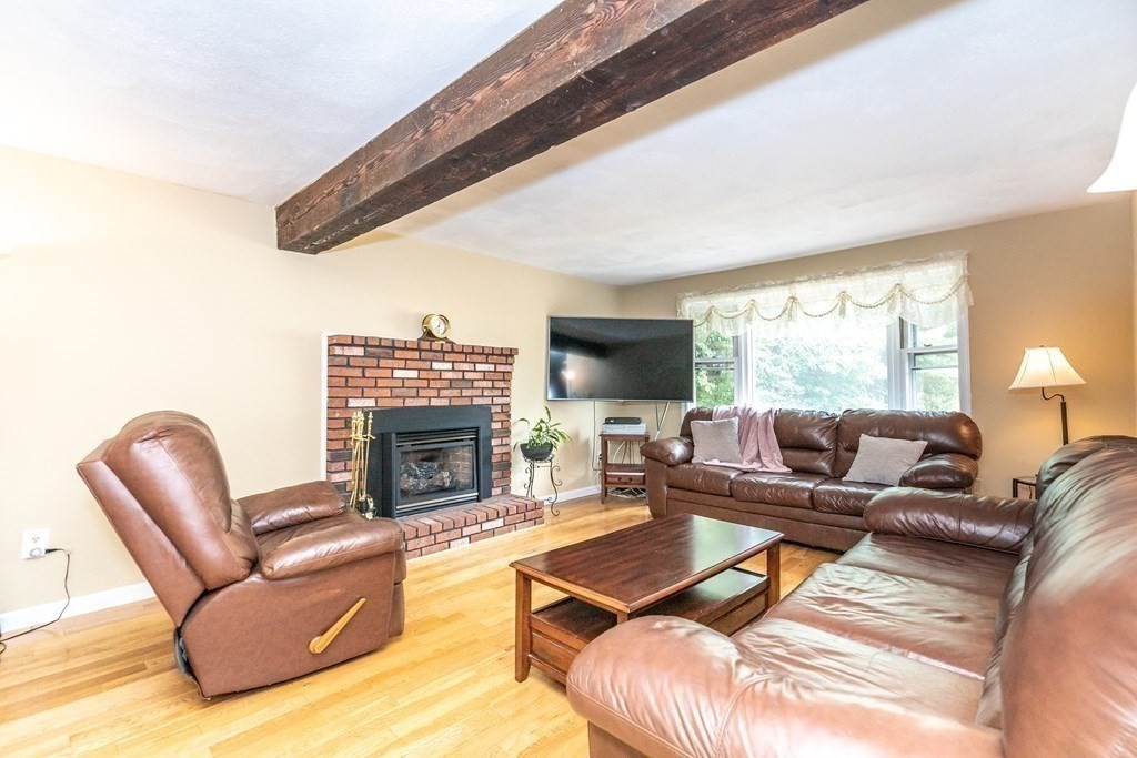 8 Comanche Circle Billerica, MA 01821 - Photo 2 of 35 a living room with furniture a fireplace and a large window