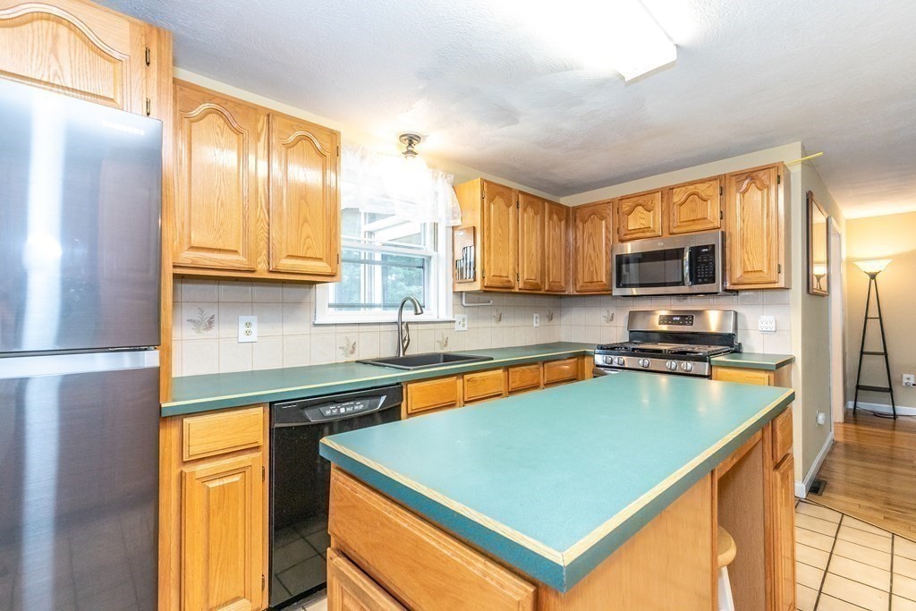 8 Comanche Circle Billerica, MA 01821 - Photo 4 of 35 a kitchen with stainless steel appliances granite countertop a sink stove and microwave