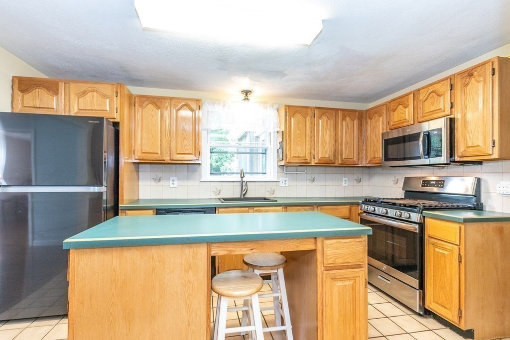 8 Comanche Circle Billerica, MA 01821 - Photo 6 of 35 a kitchen with stainless steel appliances granite countertop a sink stove and refrigerator