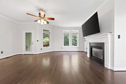 a view of a kitchen with wooden floor and a ceiling fan