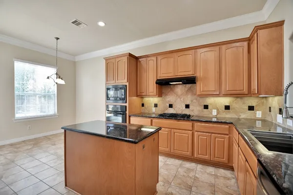 a kitchen with stainless steel appliances granite countertop a sink counter space cabinets and a large window