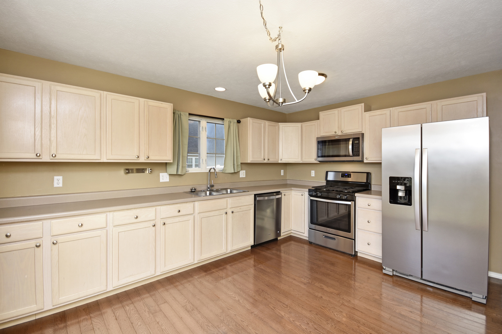 5 Andy Court, Unit 4 Bloomington, IL 61704 - Photo 13 of 52 a large kitchen with cabinets wooden floor and stainless steel appliances