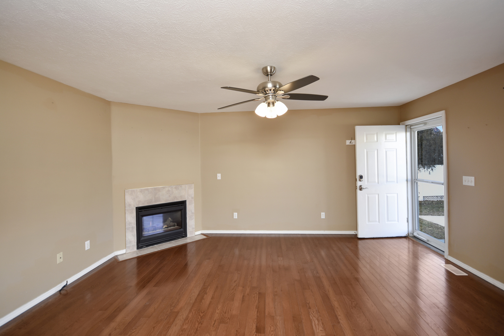 5 Andy Court, Unit 4 Bloomington, IL 61704 - Photo 4 of 52 a view of an empty room with wooden floor and fireplace