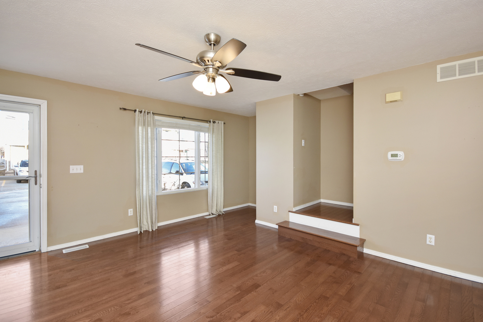 5 Andy Court, Unit 4 Bloomington, IL 61704 - Photo 7 of 52 a view of an empty room with wooden floor and a window