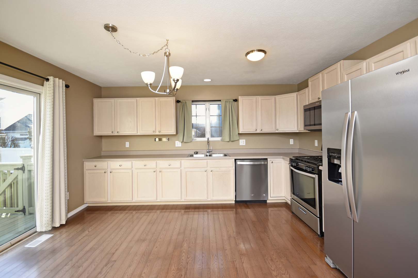 5 Andy Court, Unit 4 Bloomington, IL 61704 - Photo 10 of 52 a kitchen with a refrigerator a sink and dishwasher with wooden floor