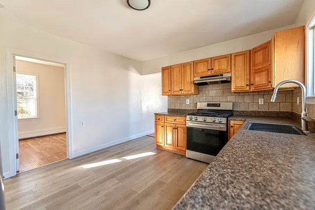 a kitchen with stainless steel appliances granite countertop a stove a sink and a refrigerator