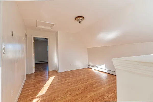 a view of a big room with wooden floor and windows