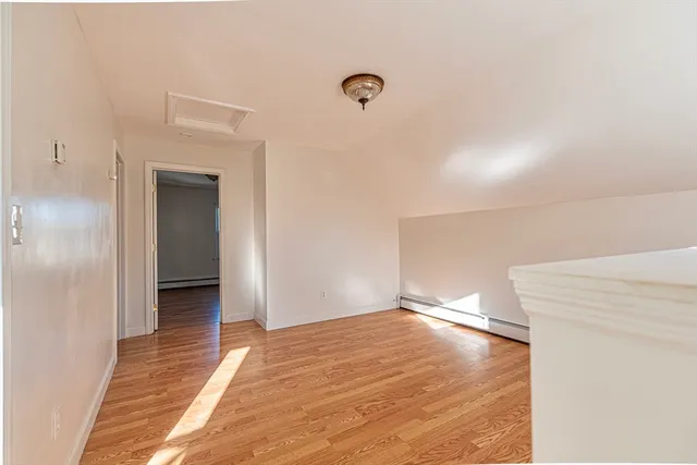 a view of a big room with wooden floor and windows