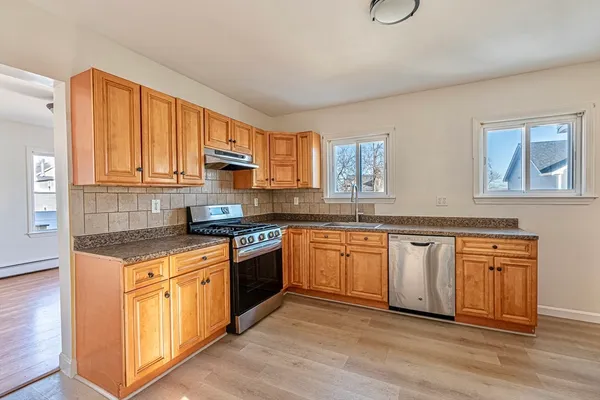 a kitchen with stainless steel appliances granite countertop a stove a sink and a microwave