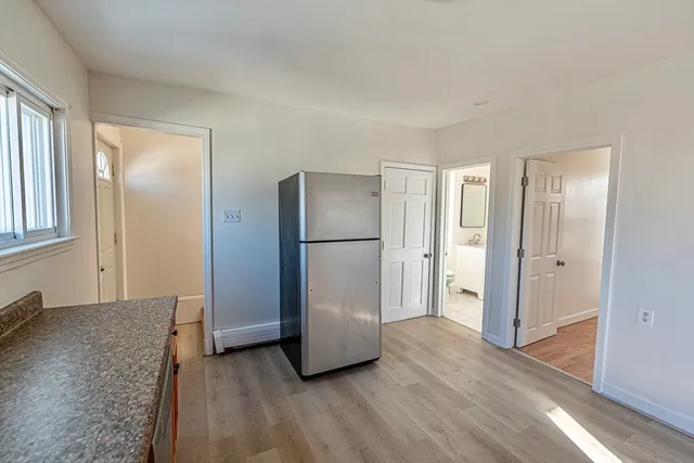 a view of an empty room and window with wooden floor