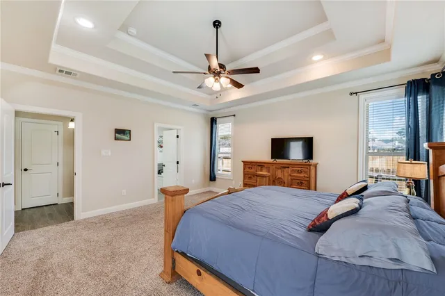 a bedroom with a bed chandelier and a window