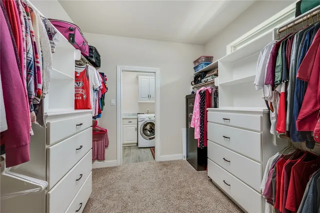a view of walk in closet with clothes and shoes