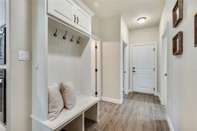 a view of a hallway with wooden floor and entryway