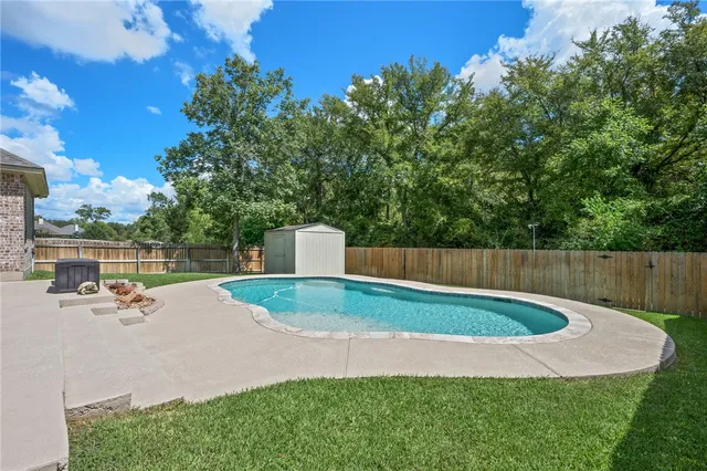 a view of a backyard with swimming pool