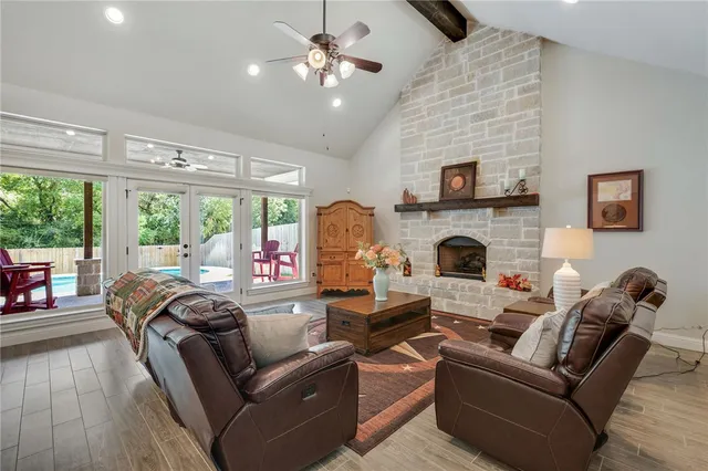 a living room with furniture a fireplace and a floor to ceiling window