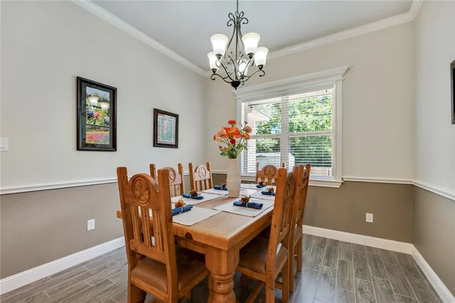 a view of a dining room with furniture a chandelier and wooden floor