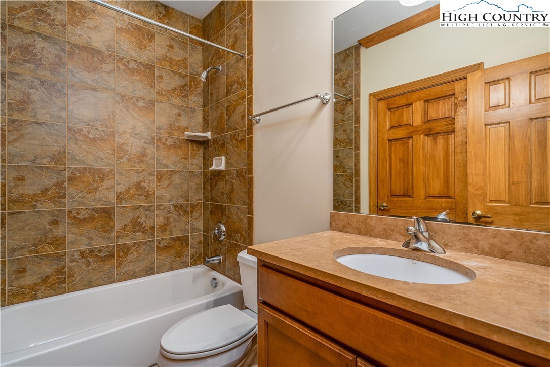 299 Trails End Extension, Unit 37C Sugar Mountain, NC 28604 - Photo 18 of 38 a bathroom with a sink a toilet and a bathtub