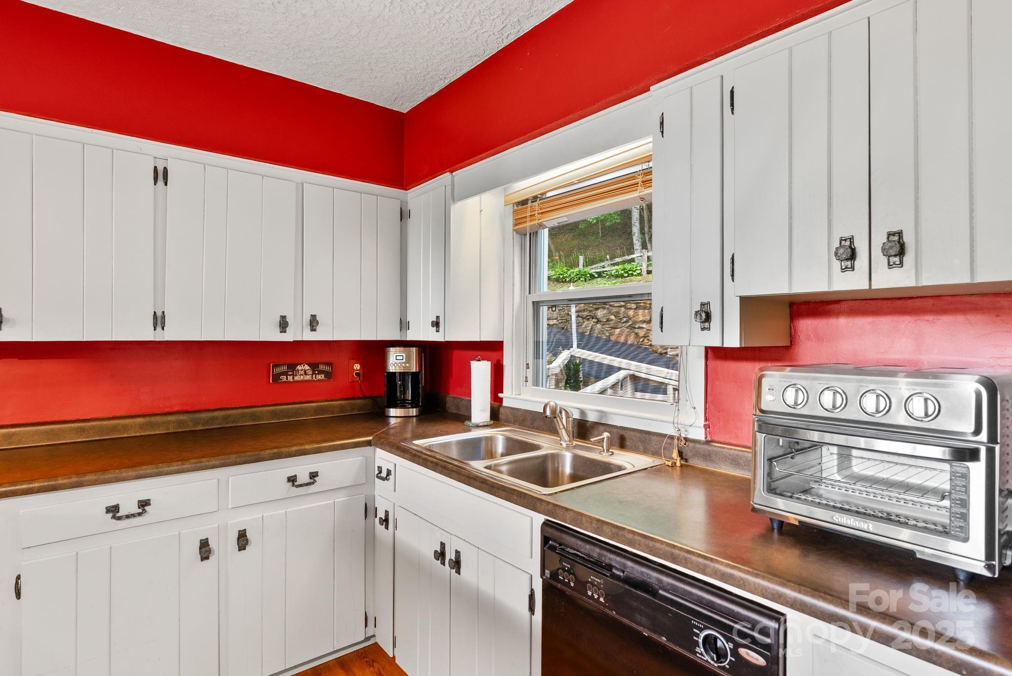 386 Country Club Drive Canton, NC 28716 - Photo 15 of 47 a kitchen with stainless steel appliances a sink dishwasher and cabinets with wooden floor