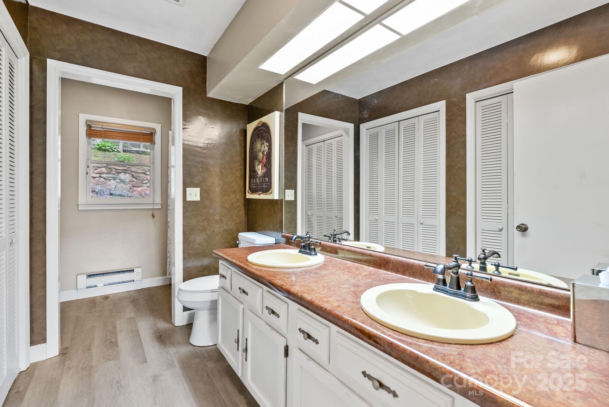 386 Country Club Drive Canton, NC 28716 - Photo 24 of 47 a bathroom with a double vanity sink a mirror and a toilet