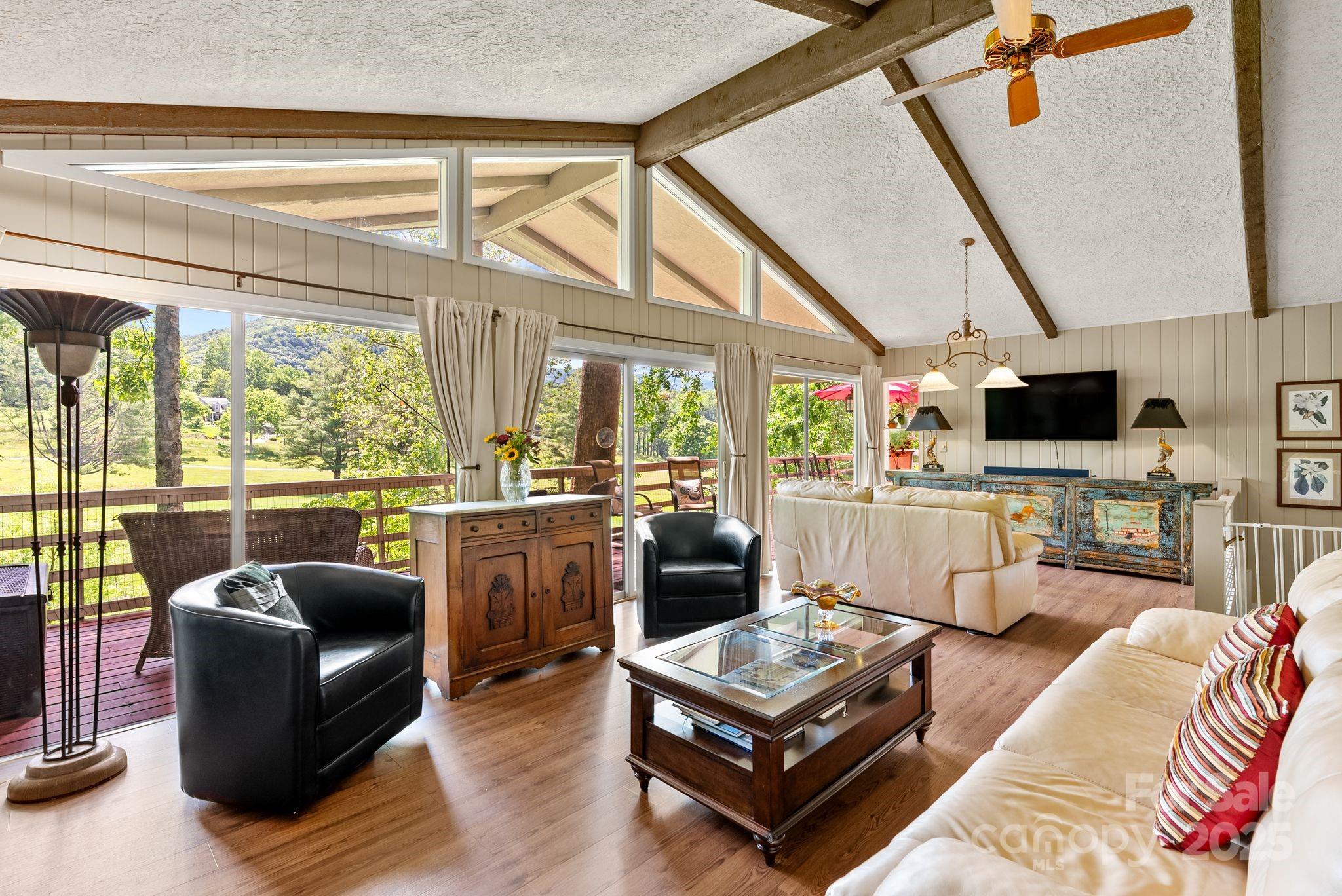 386 Country Club Drive Canton, NC 28716 - Photo 10 of 47 a living room with furniture a flat screen tv and a floor to ceiling window
