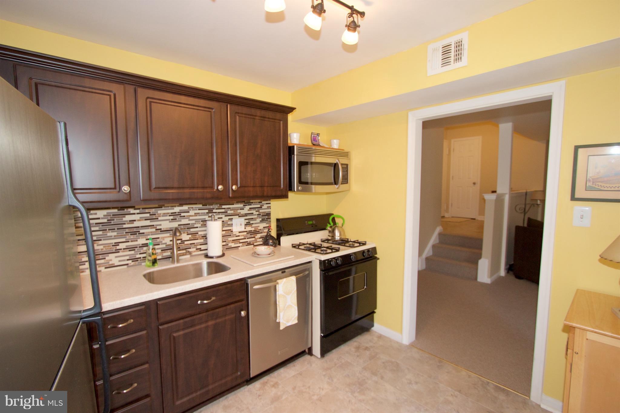 2507 Baltimore Road, Unit 1 Rockville, MD 20853 - Photo 4 of 30 a kitchen with a sink stove and cabinets