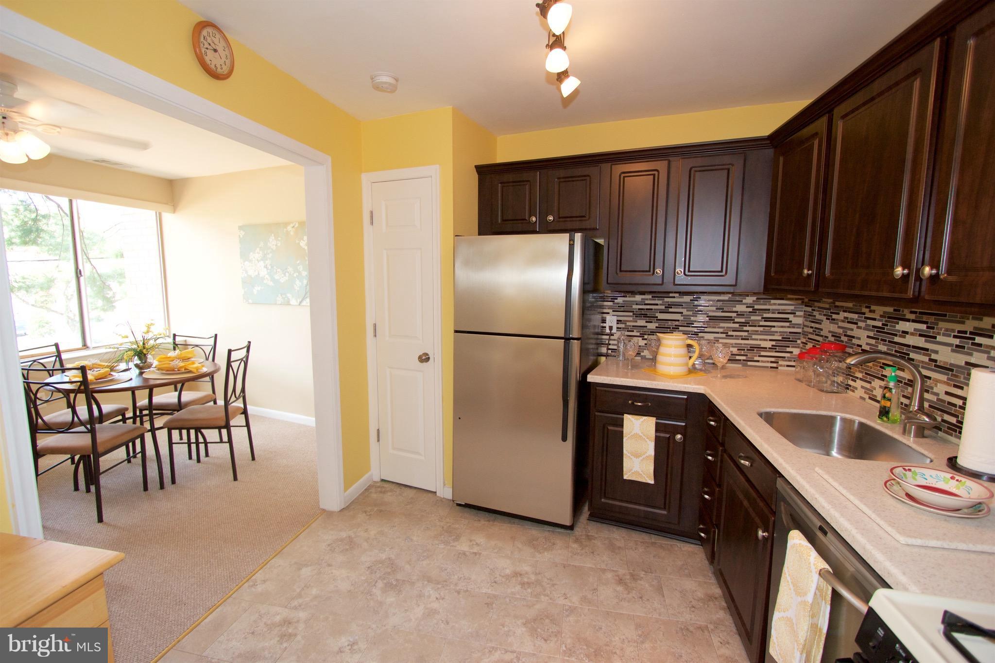 2507 Baltimore Road, Unit 1 Rockville, MD 20853 - Photo 6 of 30 a kitchen with stainless steel appliances granite countertop a refrigerator a stove a sink and a dining table with garden view