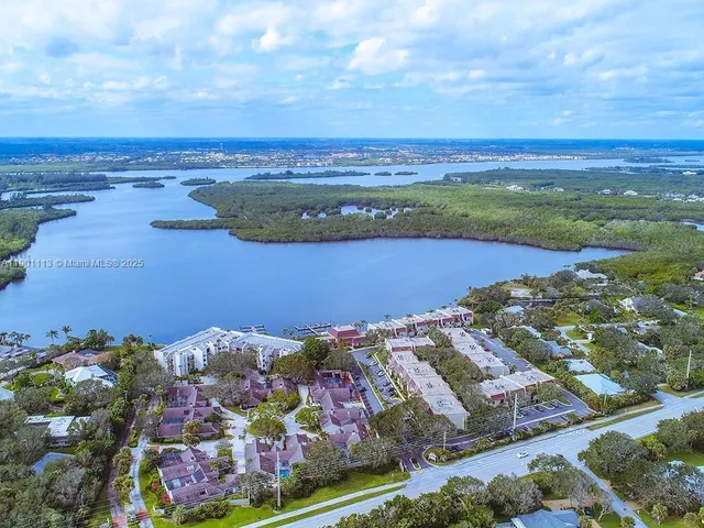 an aerial view of ocean and residential houses with outdoor space