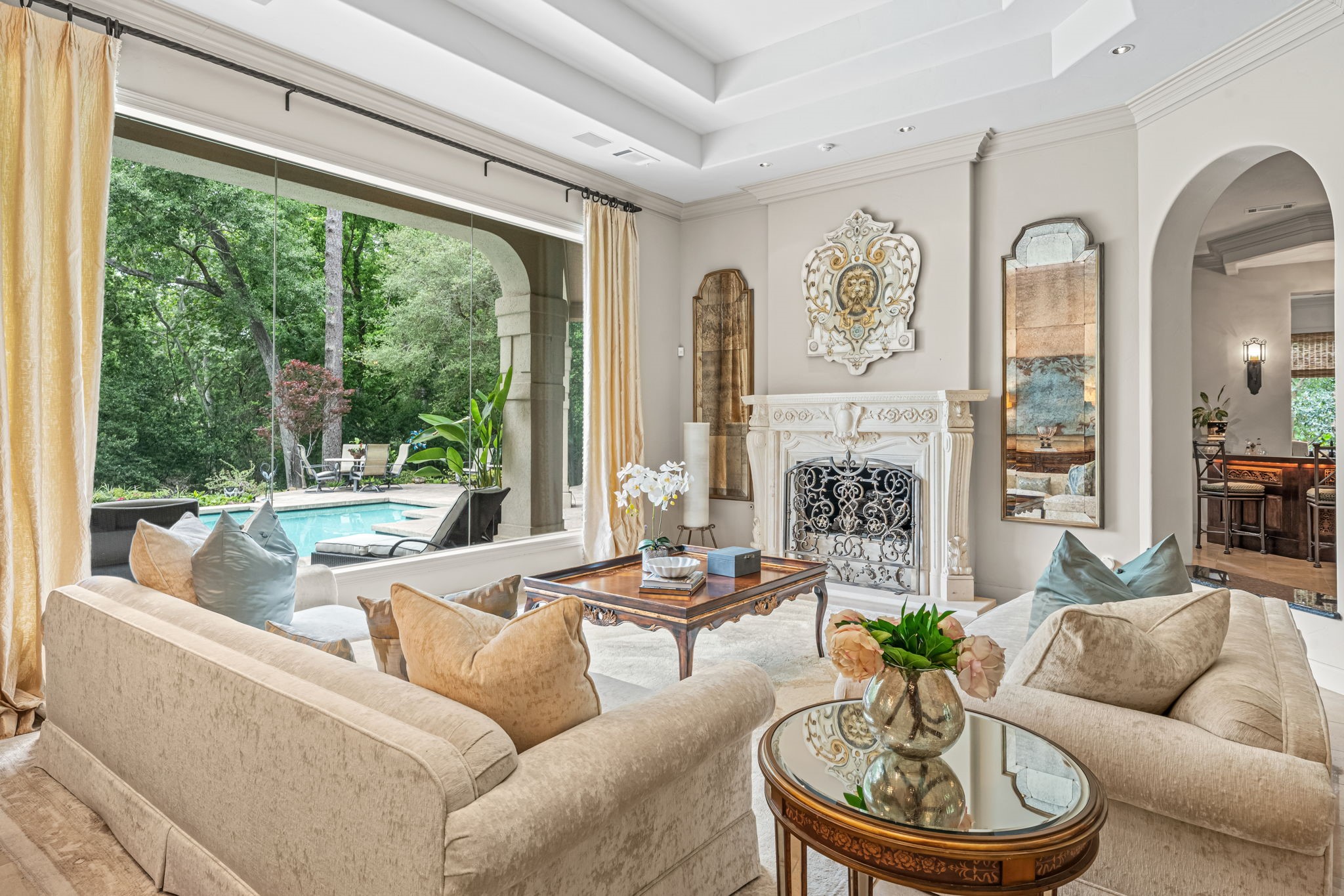 6 Mott Lane Houston, TX 77024 - Photo 15 of 50 Living room with stone mantel fireplace and spectacular views overlooking pool and backyard.