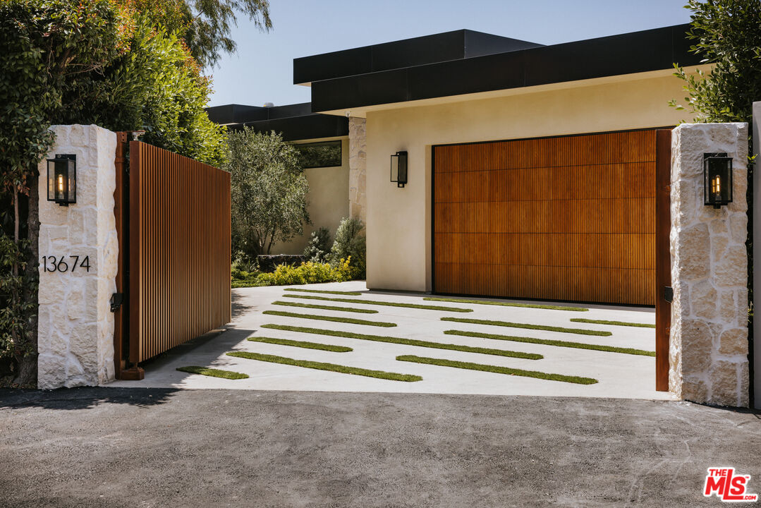 13674 Bayliss Road Los Angeles, CA 90049 - Photo 2 of 2 a front view of a house with a garage