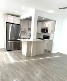 a kitchen with stainless steel appliances granite countertop a refrigerator stove and sink