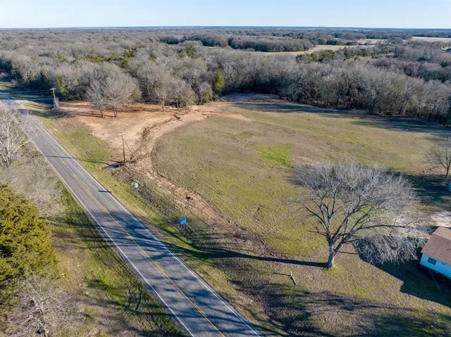 a view of a dry yard with wooden fence