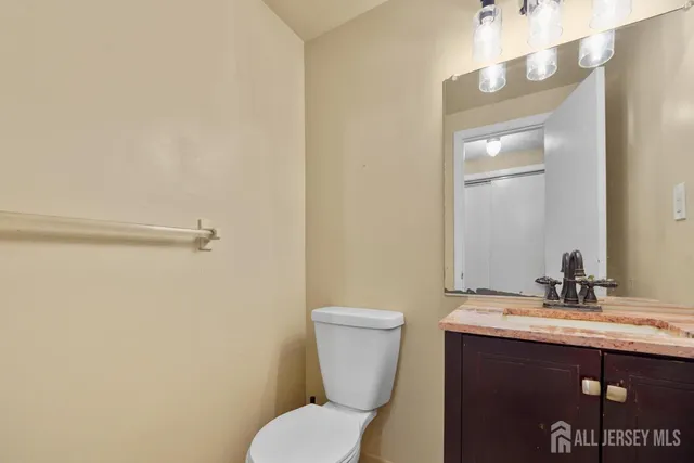 a bathroom with a sink mirror vanity and toilet
