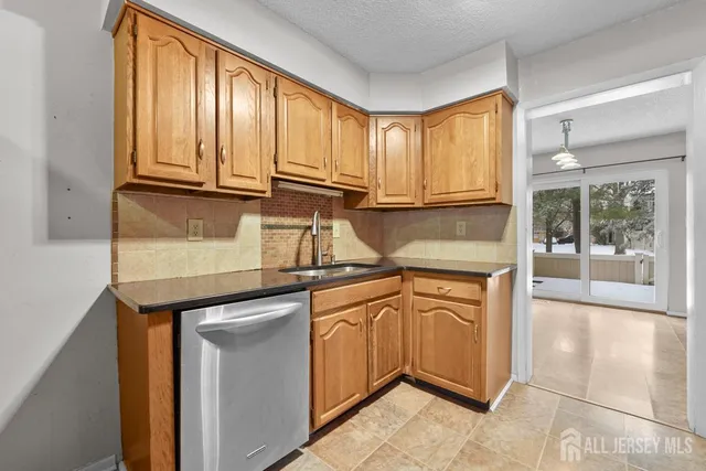 a kitchen with stainless steel appliances granite countertop a refrigerator a sink and cabinets
