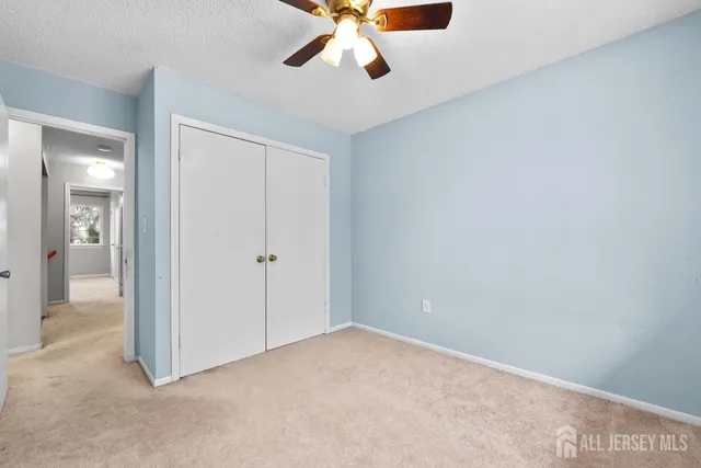 a view of a big room with closet and chandelier fan