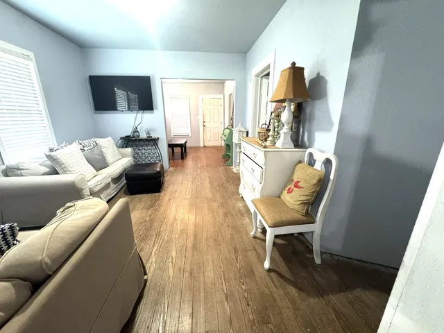 a living room with furniture and a wooden floor