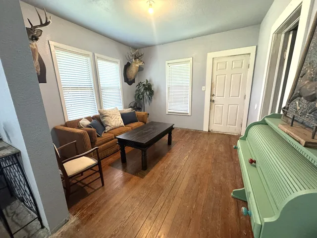 a living room with furniture and wooden floor