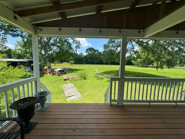 a view of a backyard with table and chairs under an umbrella