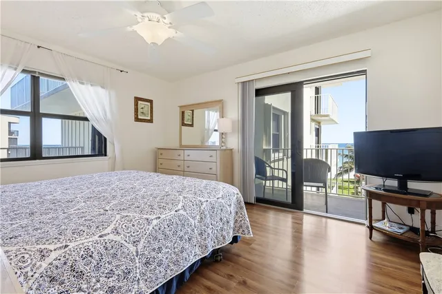 a bedroom with a bed and a flat tv screen on dresser