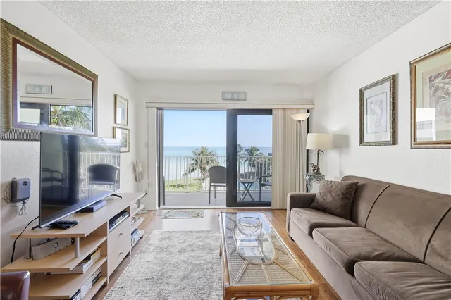 a living room with furniture a flat screen tv and a floor to ceiling window